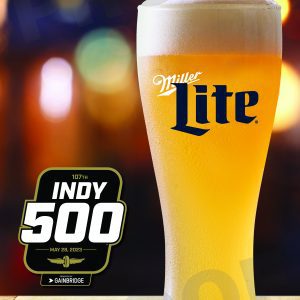 Text at top says Start Your Engine! A Miller Lite beer in a large glass sits on a bar, with blurred colors in the background. To the left of the beer is the Indy 500 racing logo.